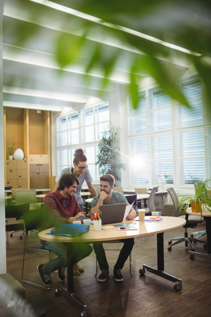 group of business executives discussing over laptop at their desk